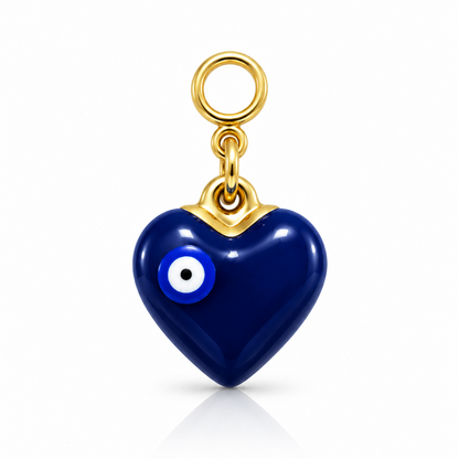 A heart-shaped evil eye pendant charm in glossy dark blue with gold-tone metal framing and a gold ring loop at the top, shown on a clean white background.