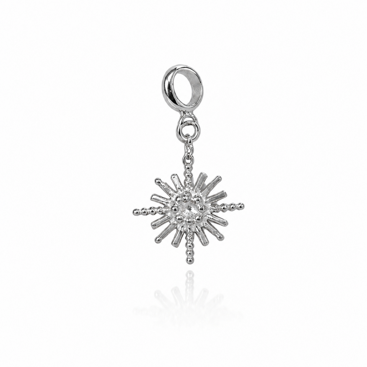 Silver sun-shaped charm on a white background